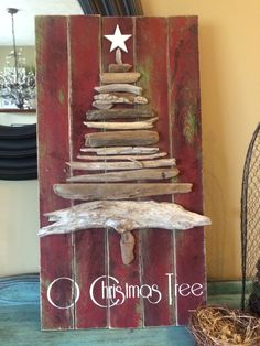 a christmas tree made out of driftwood on a table next to a bird nest