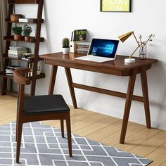 a laptop computer sitting on top of a wooden desk next to a book shelf filled with books