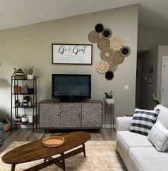 a living room filled with furniture and a flat screen tv on top of a wooden table