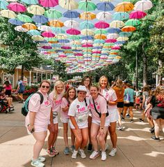 a group of young women standing under umbrellas