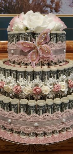 a three tiered cake with flowers and ribbons on the top is decorated with coffee cups