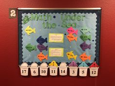 a bulletin board with fish on it and numbers in buckets next to the words math under the sea