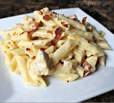 a white plate topped with pasta covered in bacon