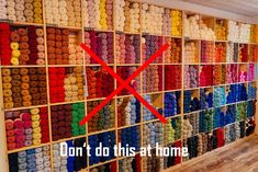 a room filled with lots of different colored balls of yarn on display in front of a wall