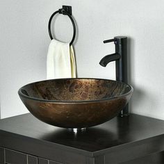 a bathroom sink with a black faucet on top of it and a white towel hanging from the wall