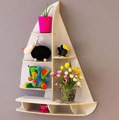 a wooden shelf with three shelves holding stuffed animals and vases on the top one is shaped like a triangle