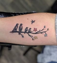 a bird on a branch with stars and a starfish tattoo design on the arm