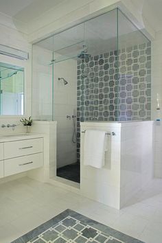 a bathroom with two sinks, a shower and a rug on the floor in front of it