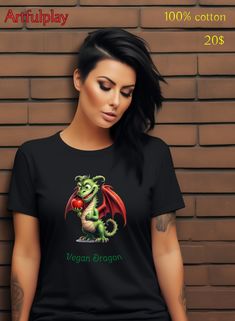 Vegan dragon tshirt go vegan tee colorful design, womens tshirts, mens tshirts and childrens shirts available. Express your vegan lifestyle and vegan power with this fun design of a cartoon dragon that eats an apple on your clothing, because dragons can be vegan too! Why not go for fruit, soy, nuts and veggies (and more!) to be more healthy and create a better world? Model is wearing slim fit 100% cotton round neck, but other colors and fits available like v-neck, comfort fit and active sports shirts. This black tee with unique vegan dragon design is available on tshirts in all sizes: S M L XL 2XL 3XL 4XL 5XL. More original positive art fashion designs for sale in Artfulplays Redbubble shop, plus other high quality products like mugs, dresses, phone cases, bags, wall-art and stickers. Dragon Tshirt, Cartoon Dragon, Going Vegetarian, Go Vegan, Positive Art, Eat Meat, Dragon Design