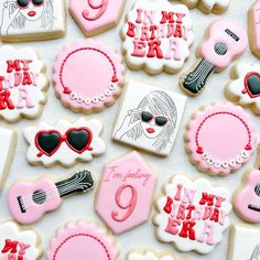 some decorated cookies are laying on a white tablecloth with pink and black decorations in the shape of women's accessories