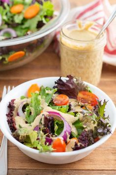 a salad in a bowl with dressing on the side