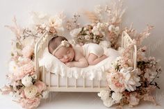 a baby sleeping in a white crib surrounded by flowers