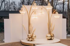 two golden vases sitting on top of a white table in front of a wall