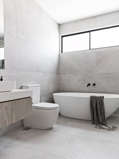 a bathroom with a large white tub next to a toilet