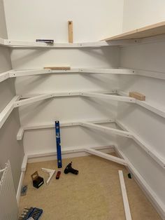 an empty room with shelves and tools on the floor