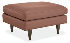 a brown ottoman with wooden legs on an isolated white background