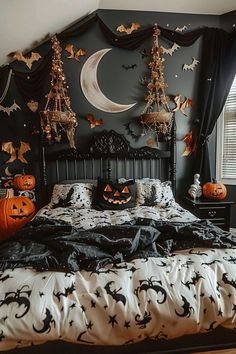 a bedroom decorated for halloween with pumpkins and bats on the wall, black bedding