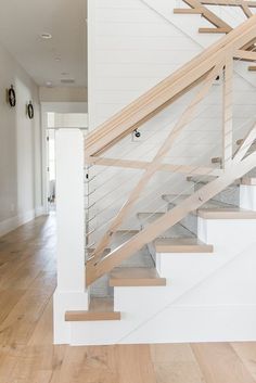 a white staircase with wooden handrails in a house