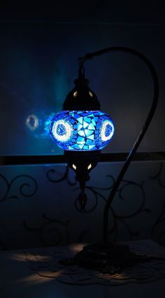 a lamp that is lit up in the dark with blue lights on it's sides