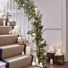 a staircase decorated with greenery and candles