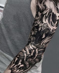 a man's arm covered in black and white ink, with flowers on it