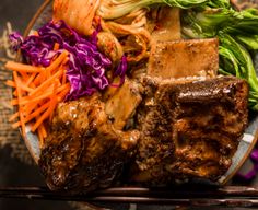 a plate filled with meat, vegetables and chopsticks on top of a table