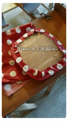 a red and white cake with polka dots on it sitting on top of a wooden table