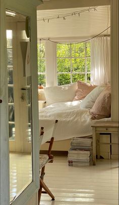 a bedroom with white walls and flooring has a bed in the corner near a window