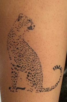 a cheetah tattoo on the leg of a woman