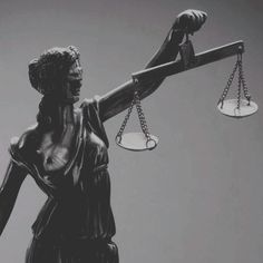 a statue of lady justice holding two scales in her right hand and the other arm raised