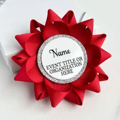 a red bow with the name event title or organization here written on it, sitting next to a white box