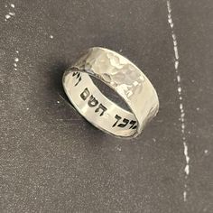 Elevate your style with this Hebrew ring featuring an intricate hammered sterling silver design. Engraved with a secret message from the Bible verse "God bless you and keep you" - "יברכך השם וישמרך" this unique piece exudes elegance and meaning. Perfect for a Jewish wedding band or a meaningful gift. This stunning sterling silver ring is more than just jewelry - it holds the powerful message "This too Shall Pass" from the Song of Solomon. The hammered design adds a touch of uniqueness and charm, making it a meaningful and stylish accessory for any occasion. Embrace tradition with a modern twist with this Hebrew ring crafted from sterling silver. Adorned with a touching Bible verse, "I Am My Beloved," this piece symbolizes love and commitment. Perfect for a Jewish wedding band or as a thoug Hammered Sterling Silver Jewelry For Promise, Spiritual Sterling Silver Engraved Ring For Anniversary, Spiritual Anniversary Engraved Ring, Adjustable Engraved Ring With Thick Band For Anniversary, Engraved Wide Band Rings As Gifts, Adjustable Thick Band Engraved Ring For Anniversary, Silver Spiritual Engraved Ring For Anniversary, Spiritual Silver Engraved Ring For Anniversary, Wedding Engraved Ring, Stamped 925, Wide Band