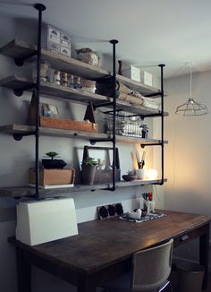 a wooden desk sitting under a shelf filled with lots of books and other items on top of it