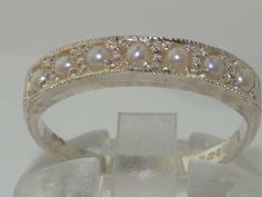 a white gold ring with pearls and diamonds