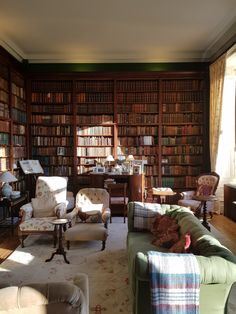 a living room filled with lots of furniture and bookshelves full of books on shelves