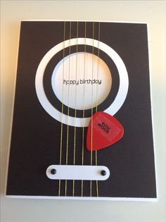 a birthday card with an acoustic guitar and a red heart on the strings that says happy birthday