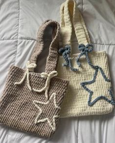 two crocheted purses sitting on top of a bed next to each other