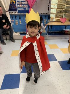 a young boy wearing a crown and cape