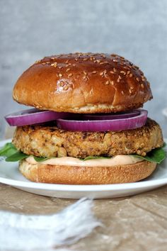 a chicken burger with onions and lettuce on a plate