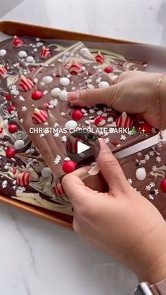 someone is decorating a chocolate christmas cake