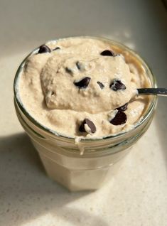 a spoon in a glass jar filled with oatmeal and chocolate chips