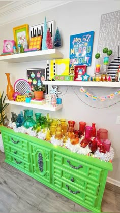 an assortment of colorful glassware is displayed on the shelf in this brightly colored room