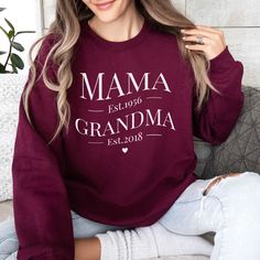 a woman wearing a maroon sweatshirt with the words mama est 2010 grandma est 2013 printed on it