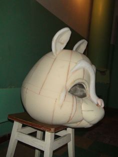 an animal head sitting on top of a wooden chair