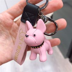 a pink keychain with a small dog on it's front and side