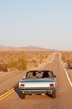 a car driving down the road in the desert