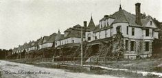 an old black and white photo of a row of houses