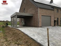 a brick house with solar panels on the roof and two men standing in front of it