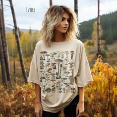 Introducing our Mushroom Identification Vintage Art T-Shirt - A captivating homage to the enchanting world of fungi! 🍄 Description: Step into a realm where artistry meets nature with our Mushroom Medley Vintage Art T-Shirt. This unique garment showcases a stunning collection of meticulously illustrated mushroom species, each accompanied by its name. Crafted with care and a deep appreciation for mycology, this shirt is a must-have for nature enthusiasts, botany lovers, and anyone who finds beaut Light Cottage Core Outfits, Artistic Oversized Printed Top, Oversized Artistic Printed Top, Oversized Printed T-shirt For Fall, Artistic Oversized Fall Tops, Fall Graphic Tee With Vintage Print, Artistic Relaxed Fit Printed Tops, Oversized Crew Neck Top With Vintage Print, Artsy Printed Cotton Tops