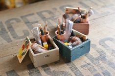 two wooden boxes filled with pencils and other art supplies on top of a table